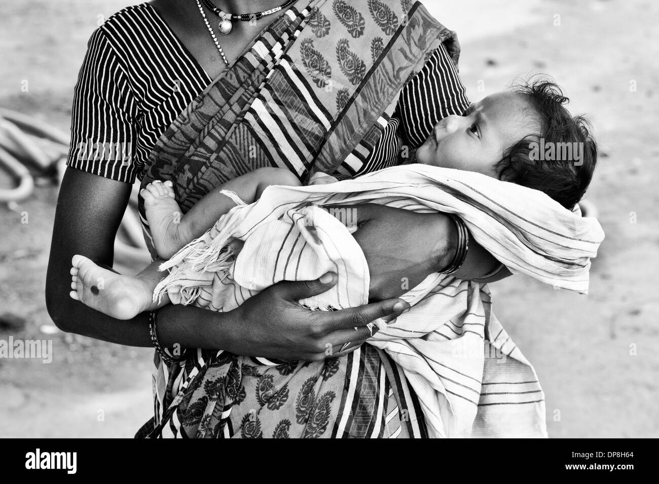 Lower caste Indian woman cradling her baby. Andhra Pradesh, India . Monochrome Stock Photo