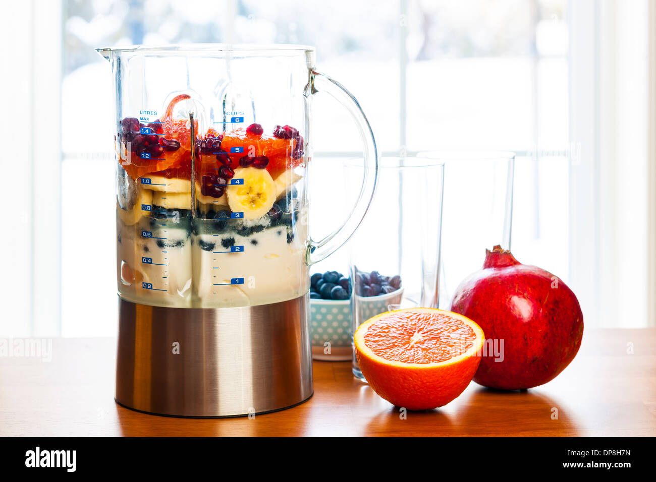 Healthy smoothie ingredients in blender with fresh fruit ready to blend