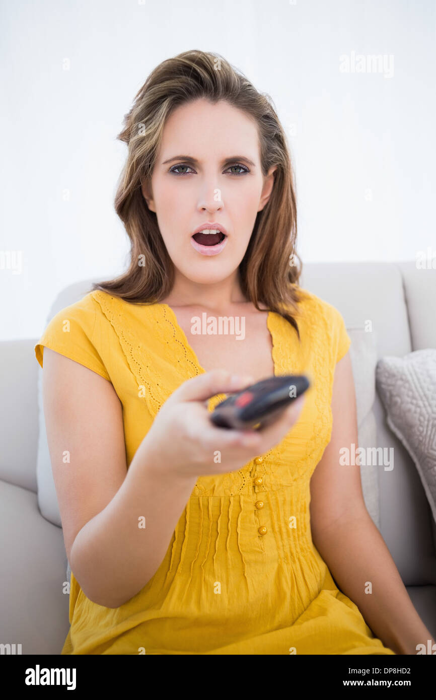Surpised woman holding remote control Stock Photo Alamy