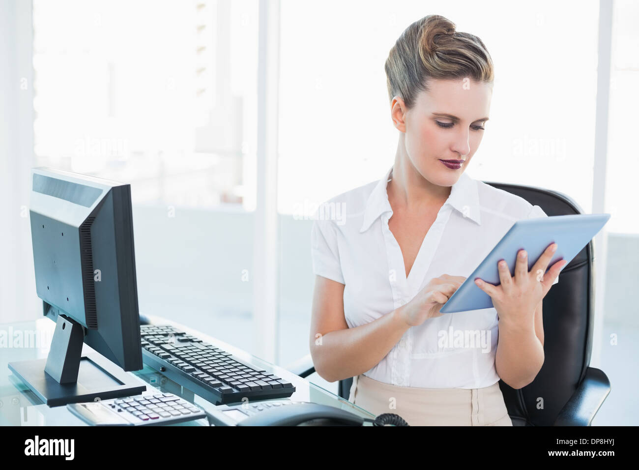 Focused businesswoman using her digital tablet Stock Photo