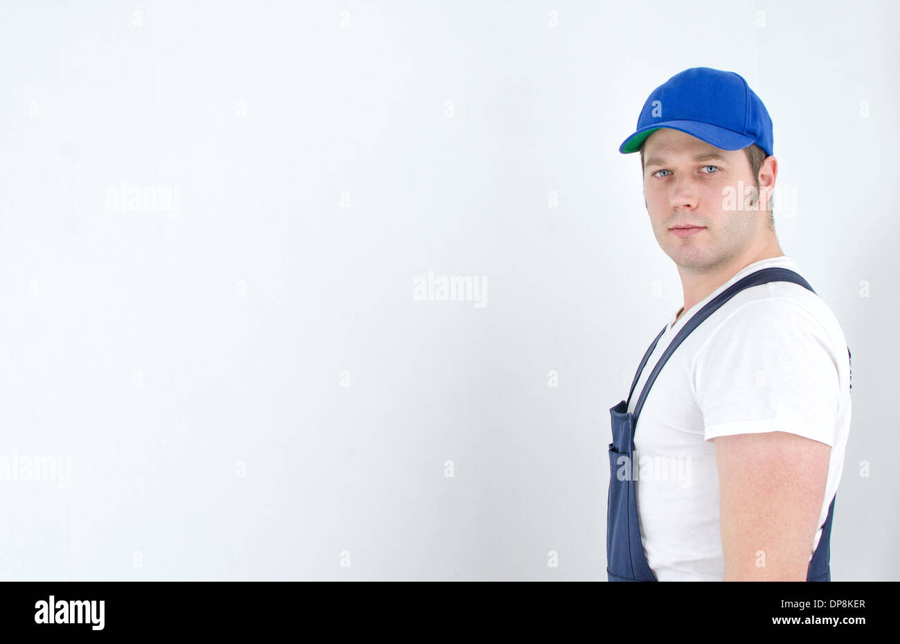 Tradesman in uniform standing near the wall. Space for your text. Stock Photo
