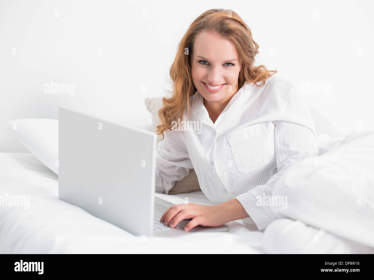 Relaxed pretty woman using a laptop lying on her bed Stock Photo - Alamy