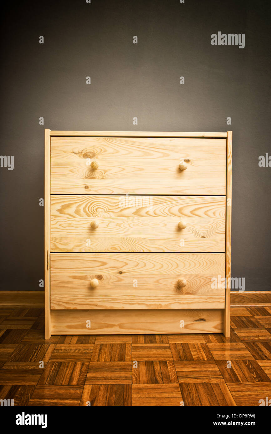 Simple closed wooden cabinet with drawers in room Stock Photo