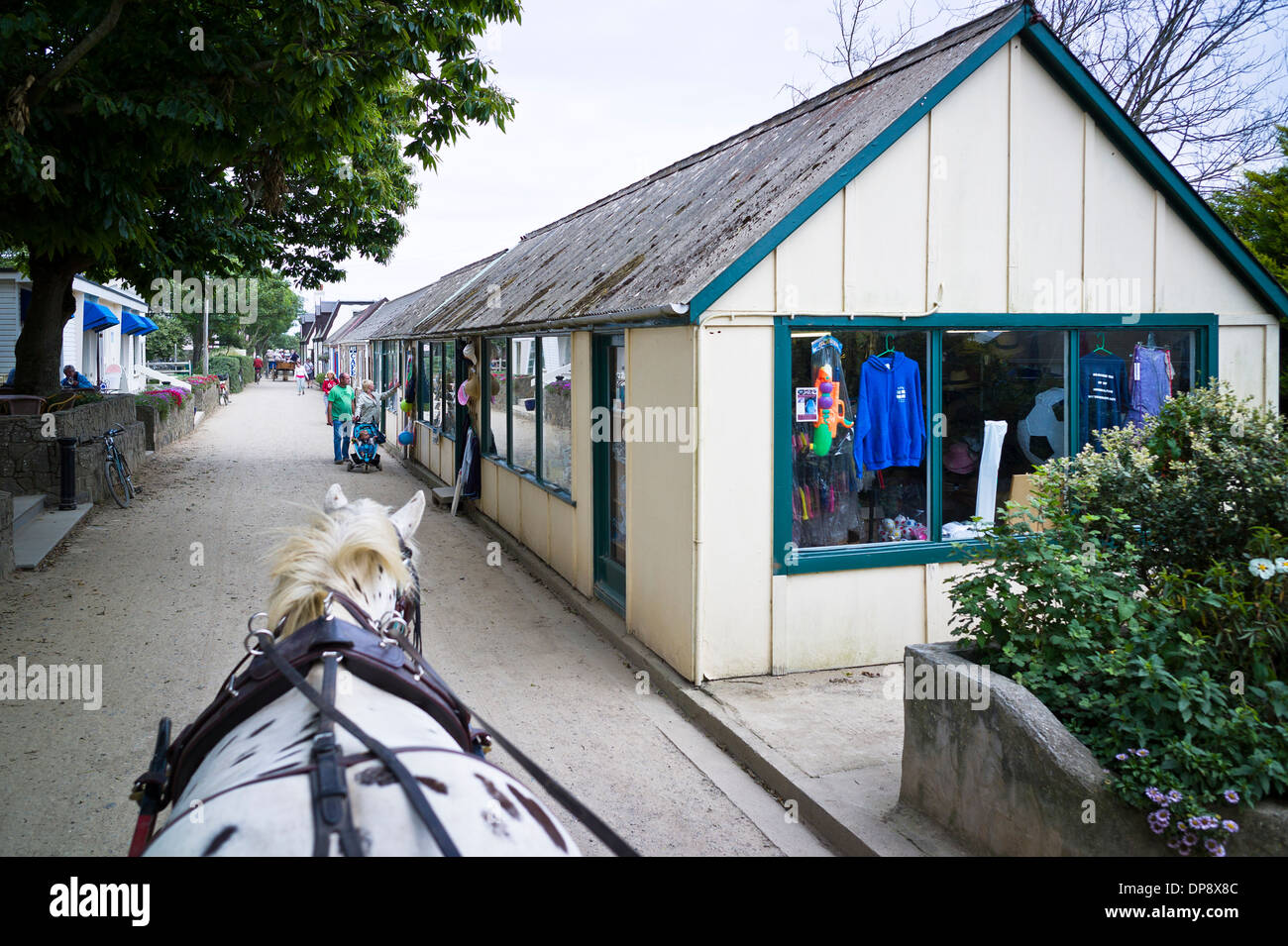 Horse ride through Sark village shops avenue Stock Photo