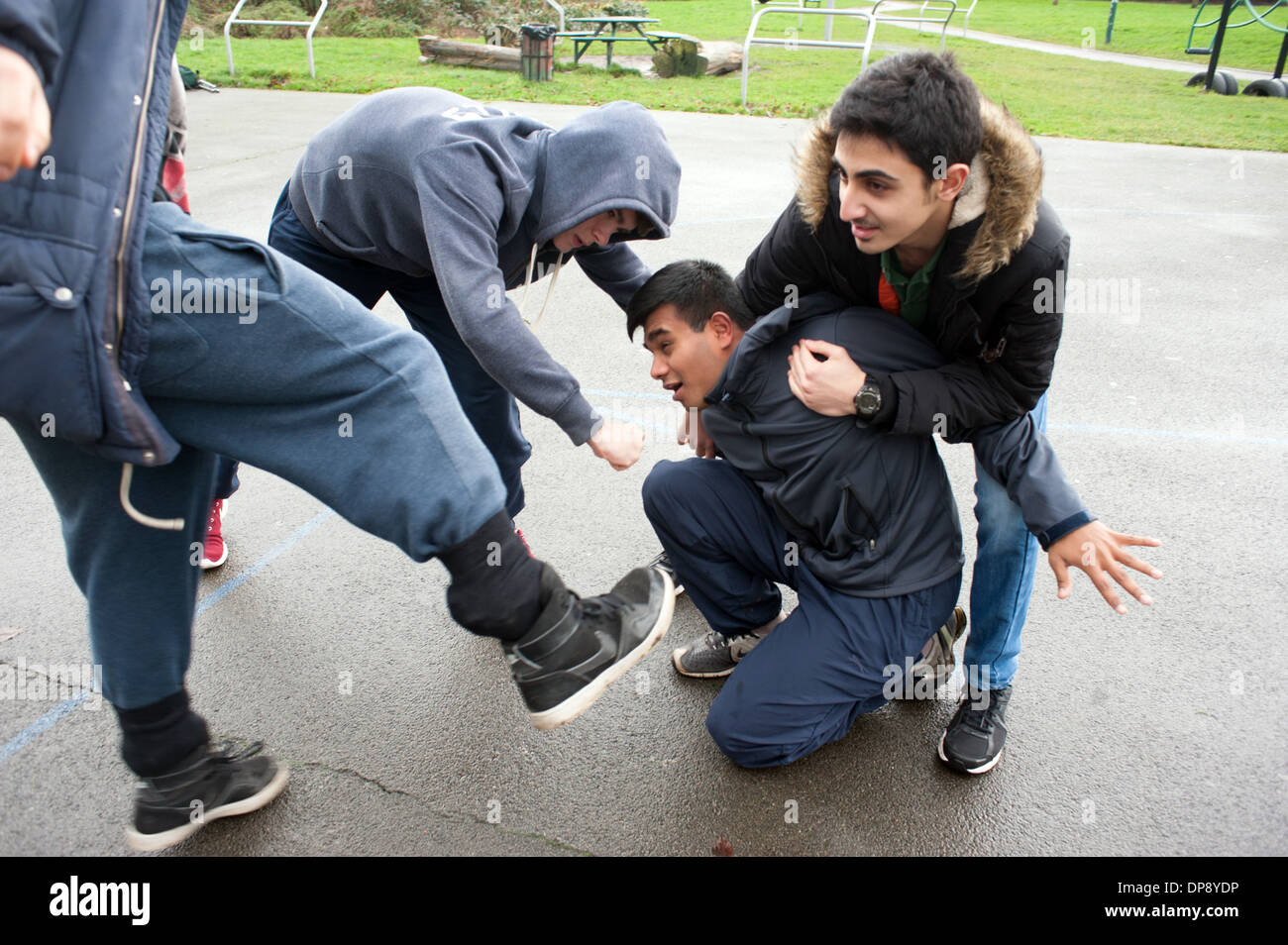 A teenage boy being assaulted by a group of boys. Stock Photo