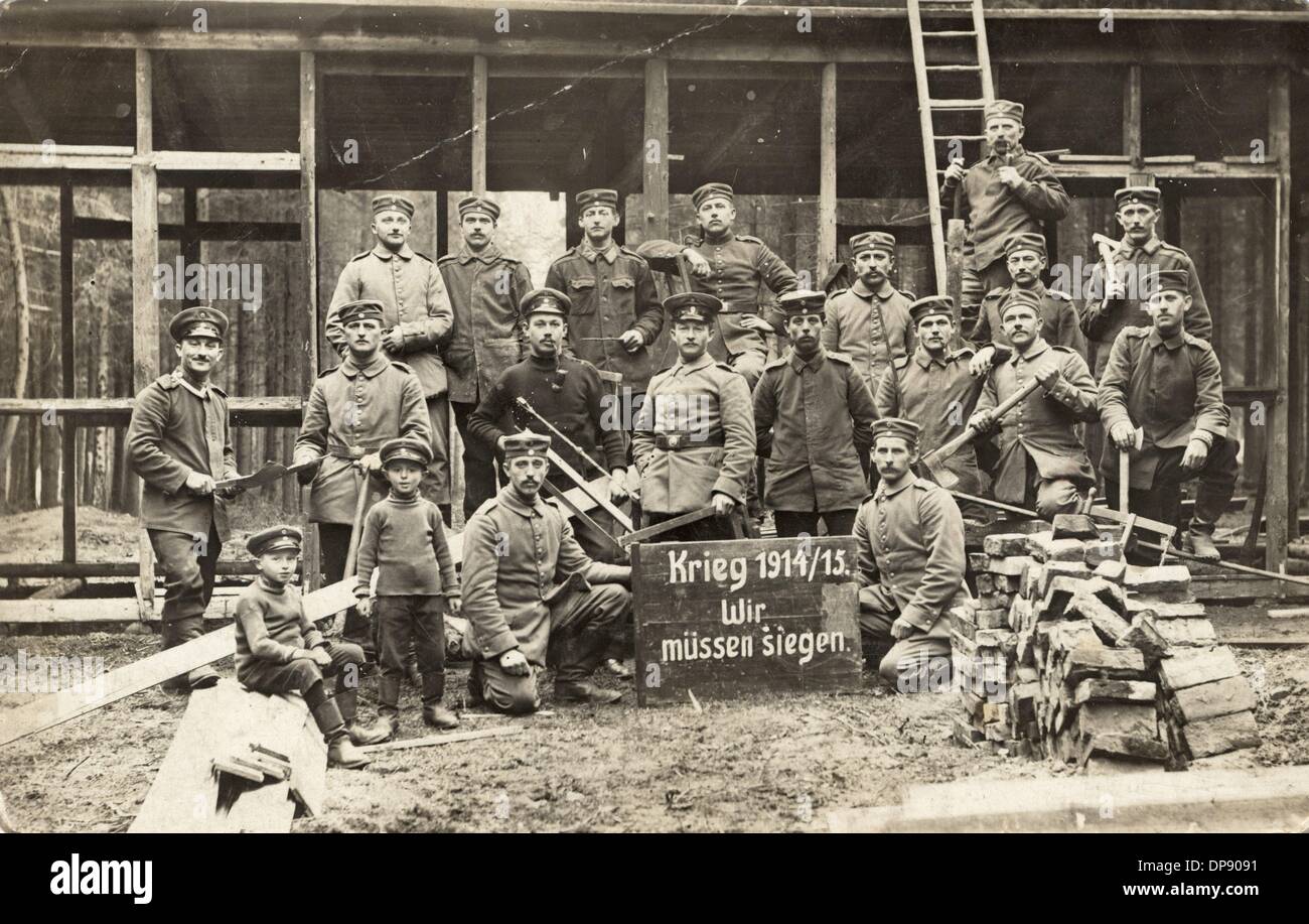A postcard from World War I shows a group of soldiers who have gathered around a wooden board with the writing 'War 1914/1915. We have to win'. The postcard has a stamp of the city Chemnitz in Saxony, Germany. Photo: Collection Sauer Stock Photo