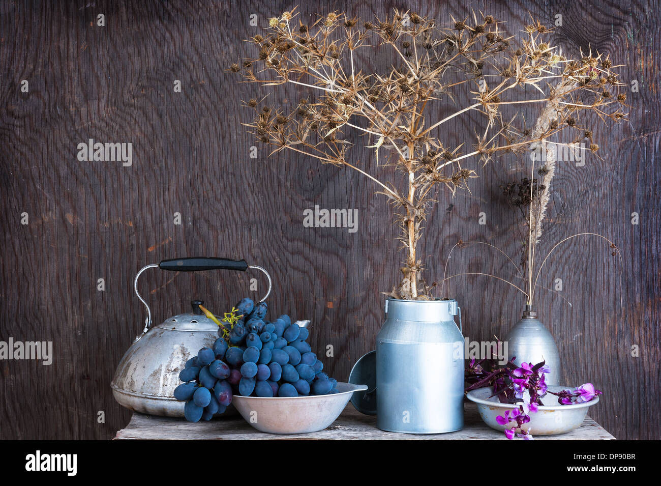 Kitchen utensils on the wooden background with dry autumn prairie flowers Stock Photo