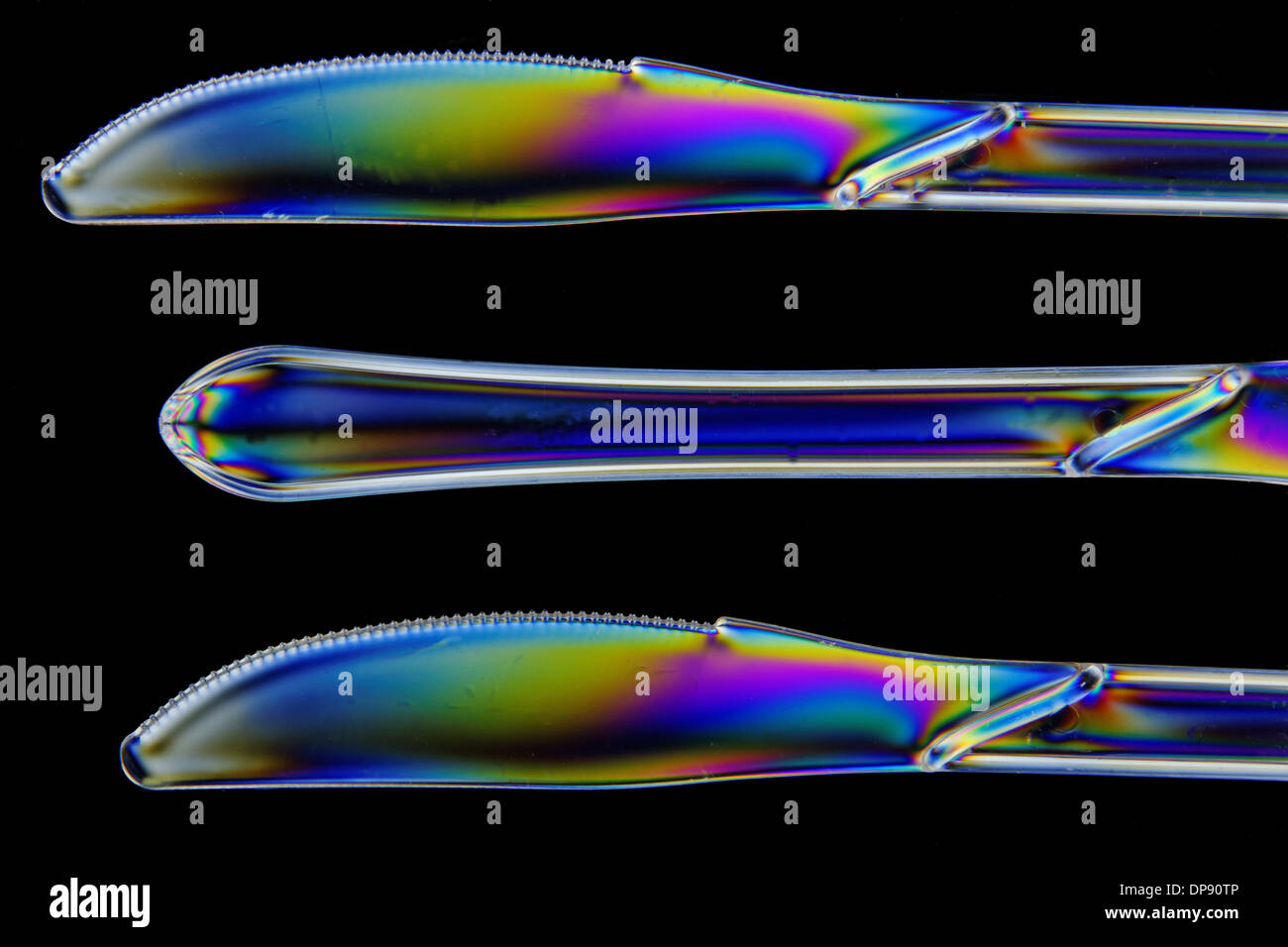 Plastic knives shot in double polarised lighting, in closeup Stock Photo