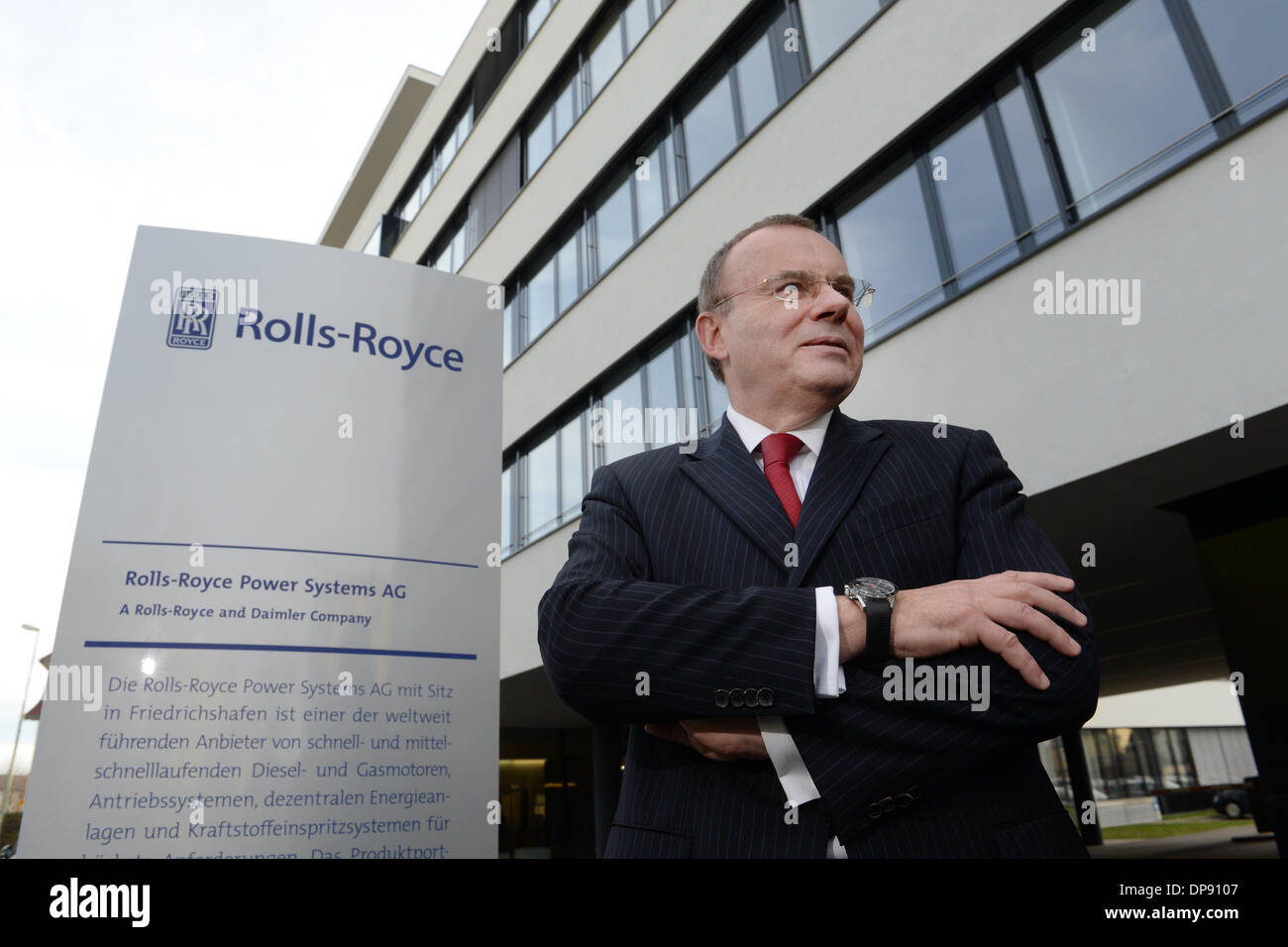 Friedrichshafen, Germany. 09th Jan, 2014. Ulrich Dohle, CEO of Rolls-Royce  Power Systems AG poses next to the new logo outside of the management  buildings after a press conference in Friedrichshafen, Germany, 09