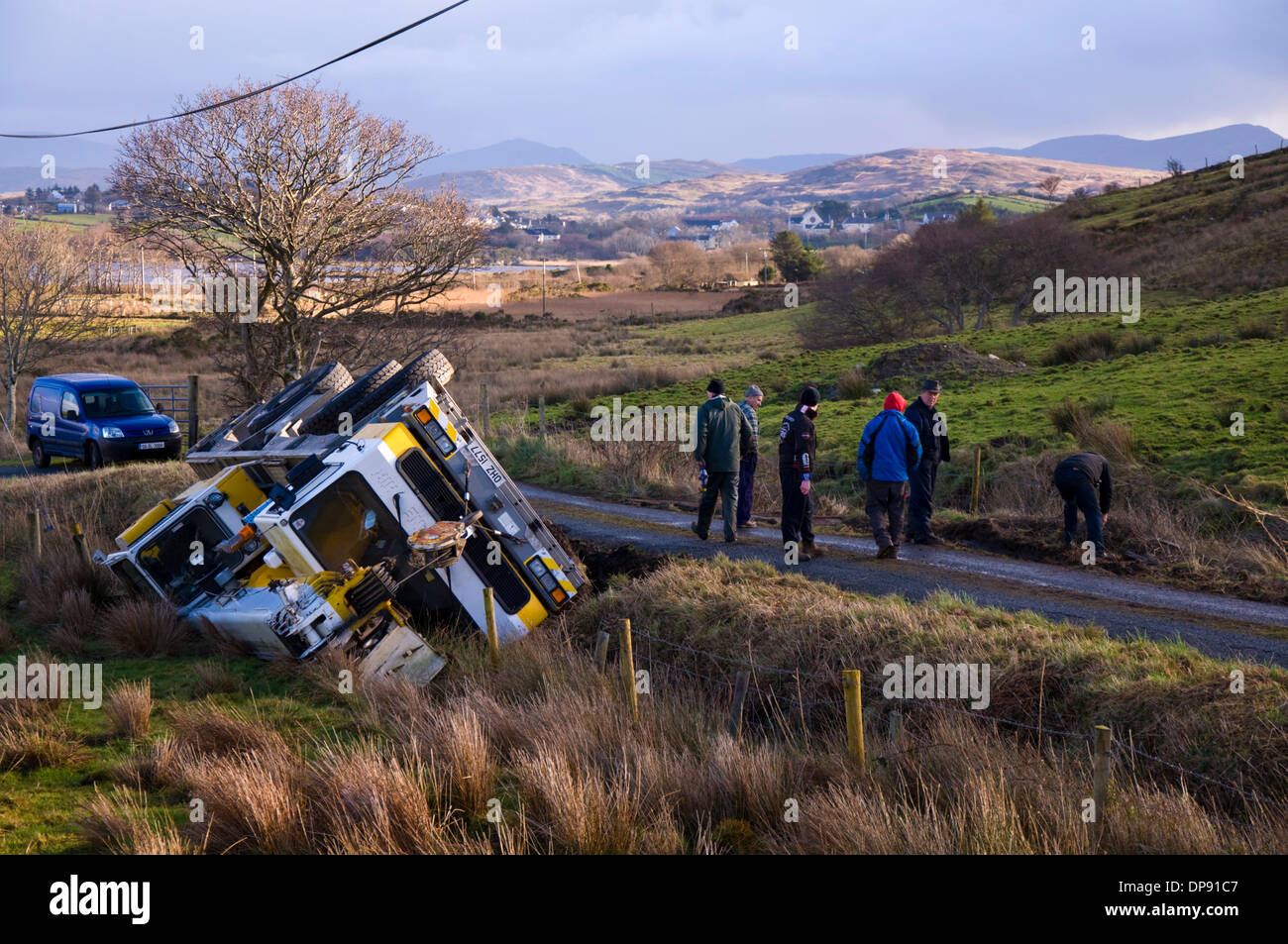 Ardara, County Donegal, Ireland. 9th January 2014. A heavy crane fell off a country road into a ditch after heavy rains had destabilised the verge. Nobody was hurt in the accident. Local people at the scene investigate. Photo By:Richard Wayman/Alamy Live News Stock Photo