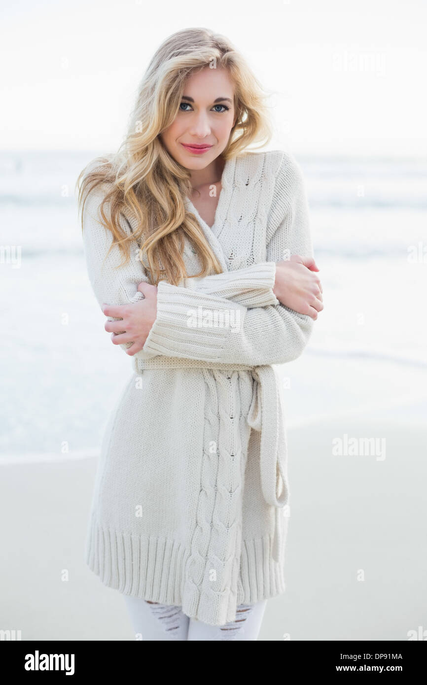 Attractive blonde woman in wool cardigan looking at camera Stock Photo -  Alamy