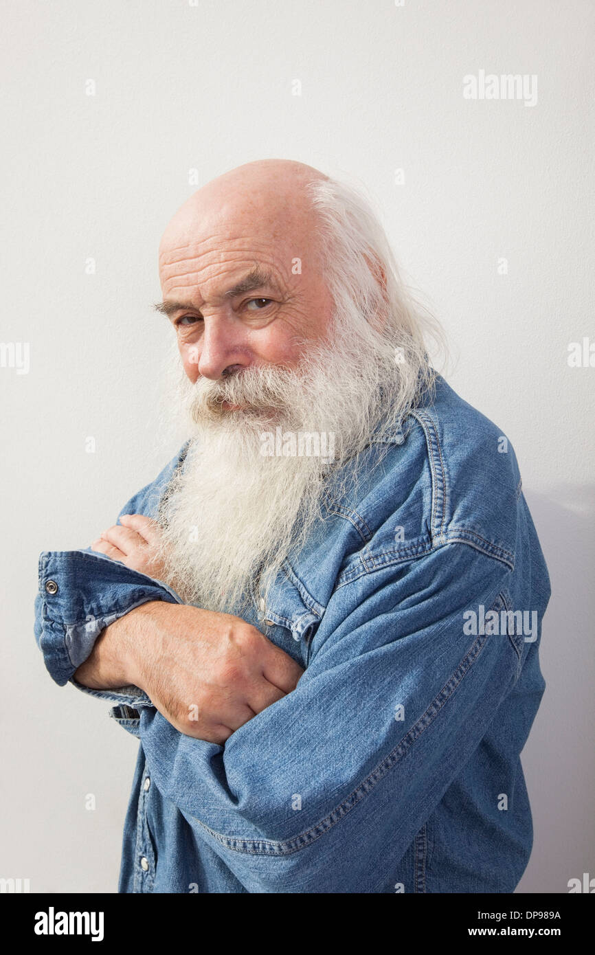 Portrait of senior man with arms crossed over gray background Stock Photo