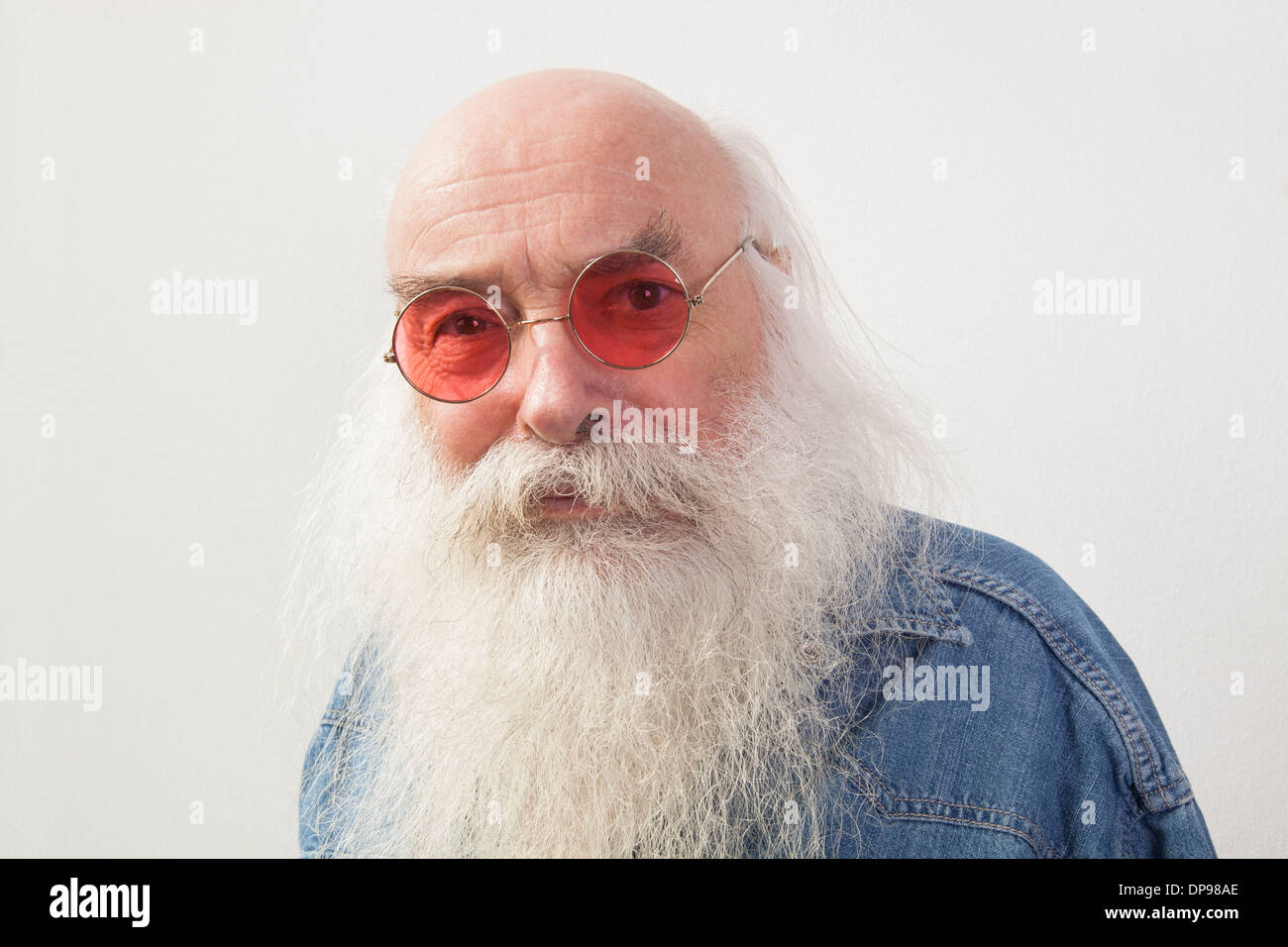 Portrait of senior man wearing red glasses over gray background Stock Photo