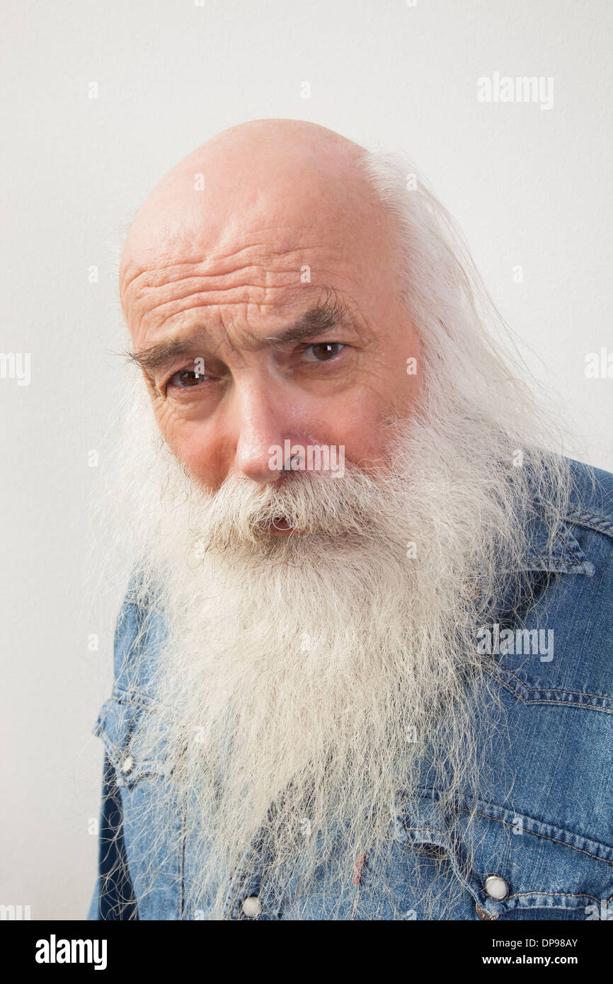 Portrait of suspicious senior man over gray background Stock Photo