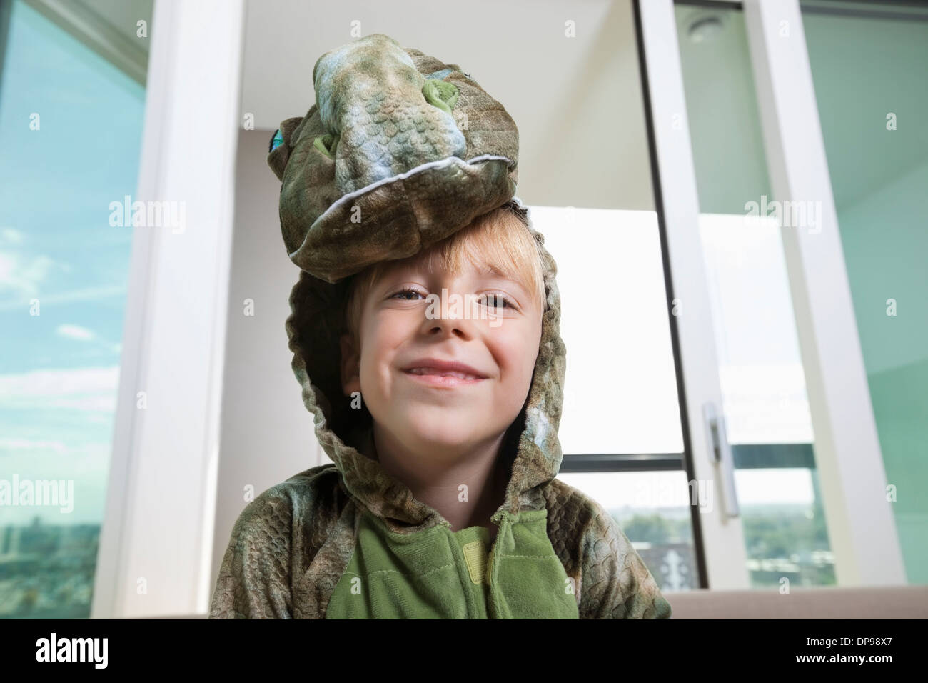 Portrait of smiling boy in dinosaur costume at home Stock Photo