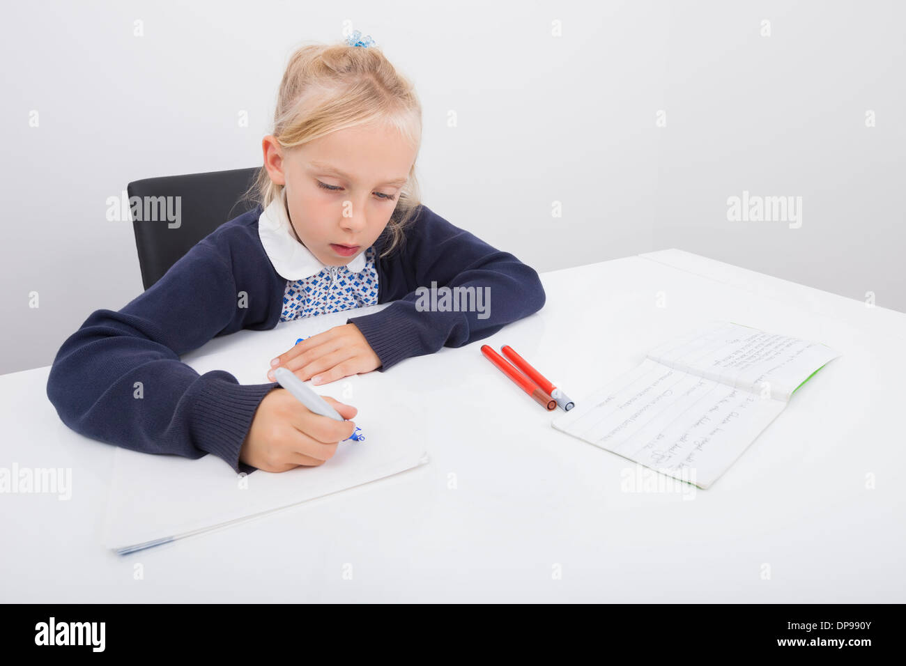 Girl drawing on paper with felt tip pen at table Stock Photo