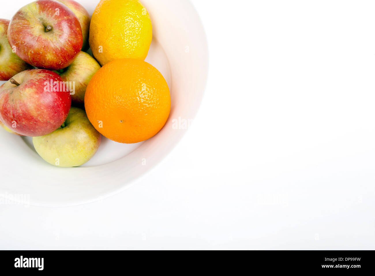 Fresh apples with orange and lemon in plate against white background ...