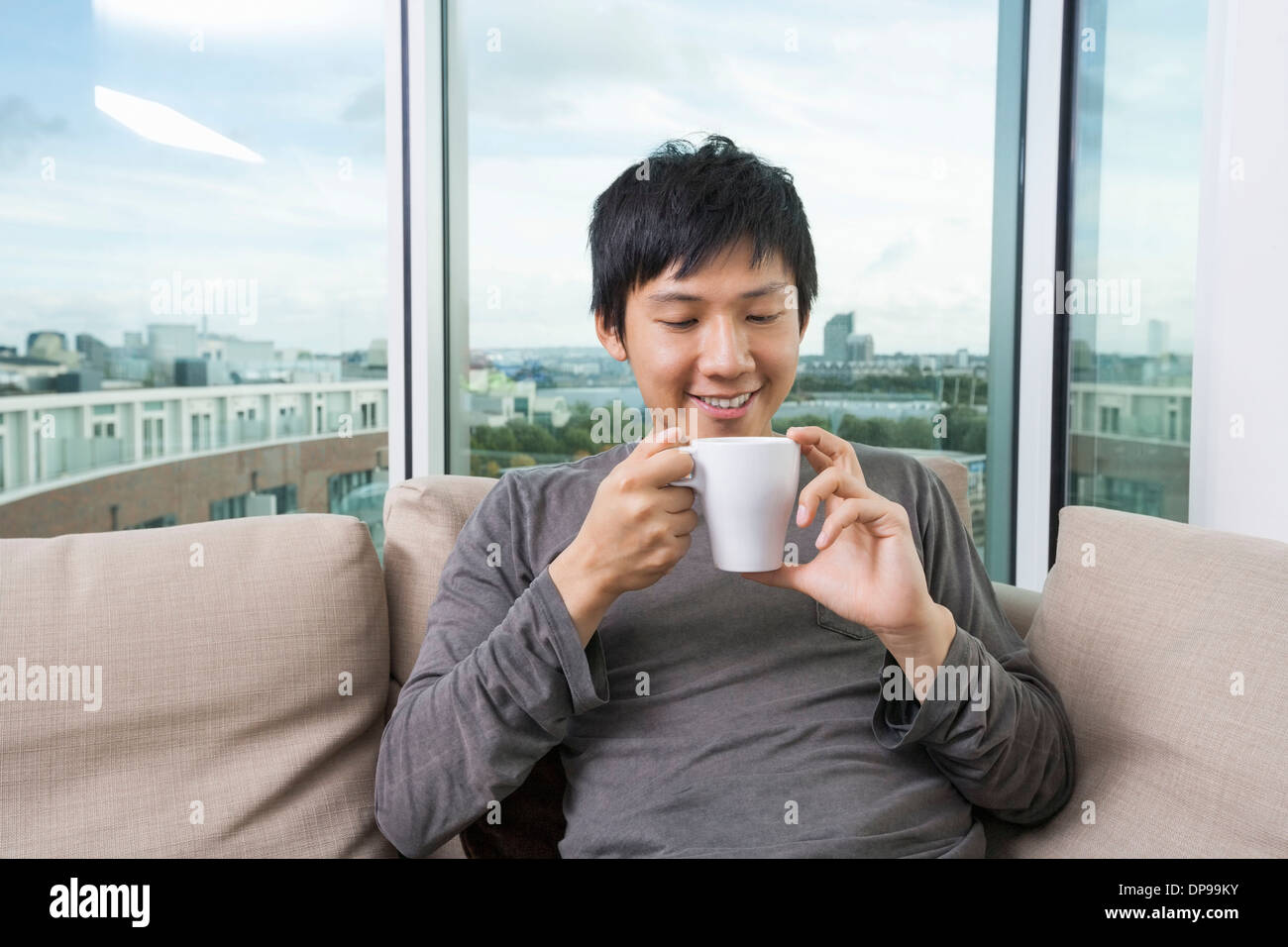 Mid adult man holding coffee cup in house Stock Photo