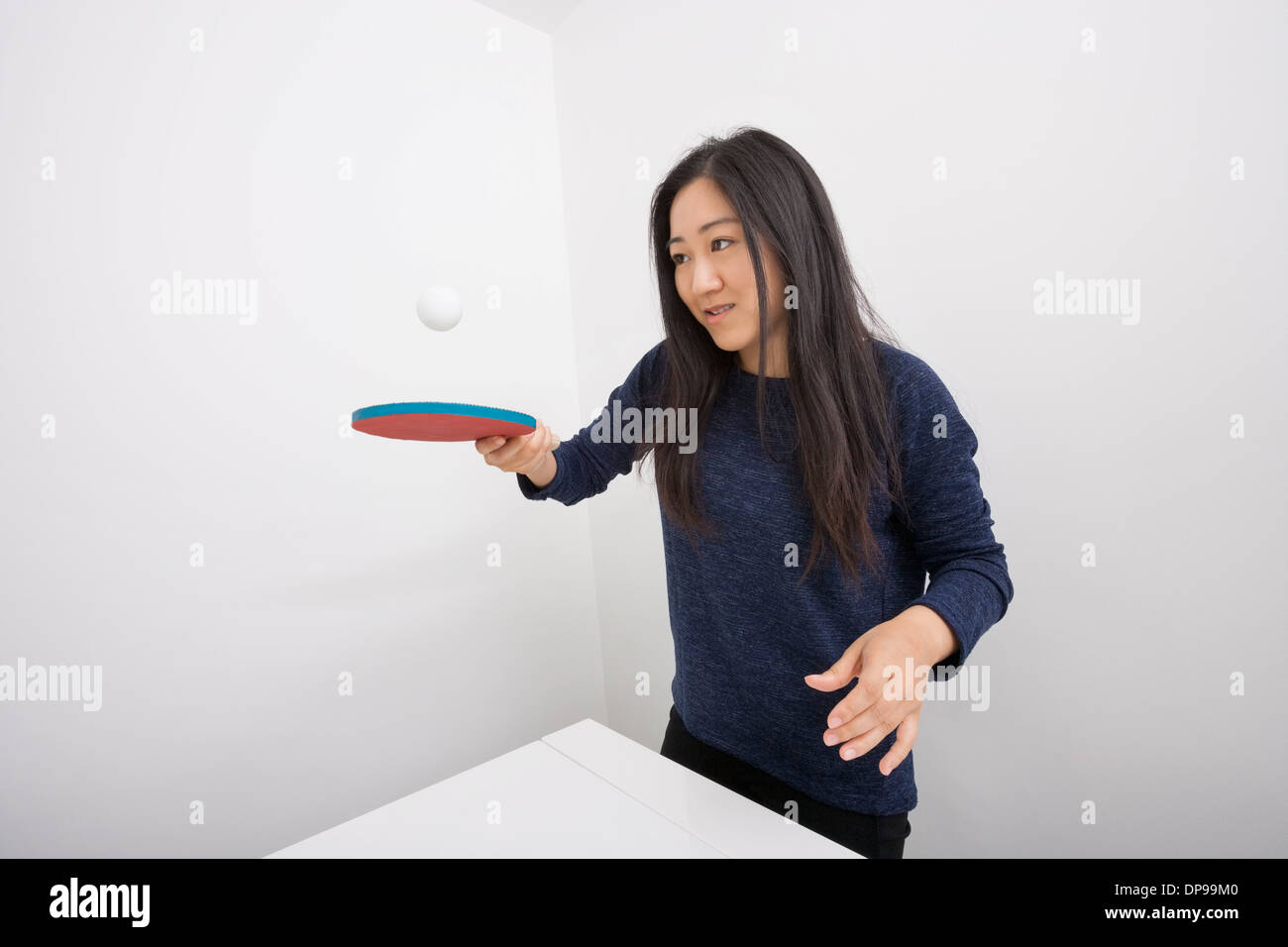 Female table tennis player bouncing ball on paddle Stock Photo