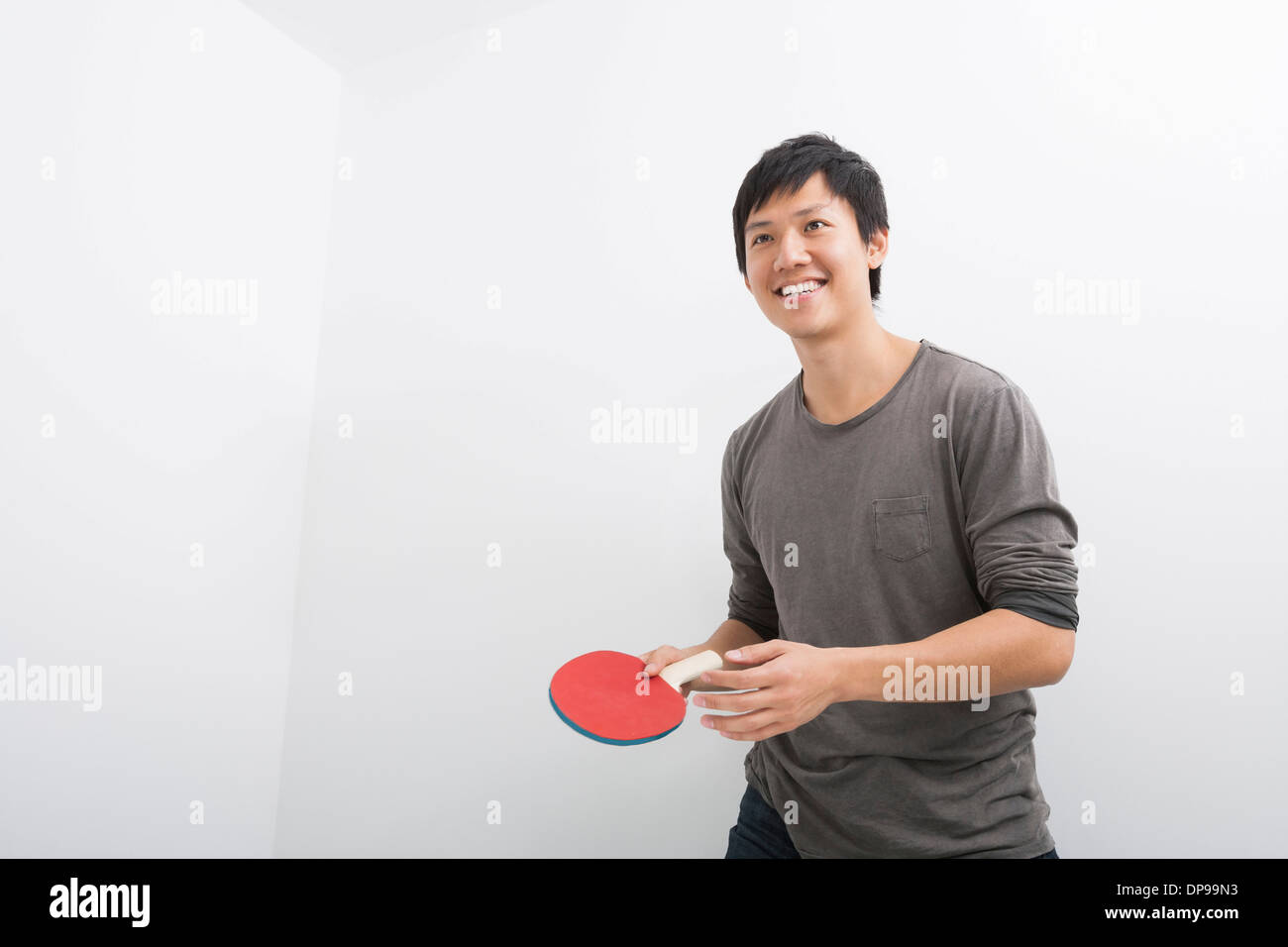 Handsome mid adult man holding table tennis paddle Stock Photo