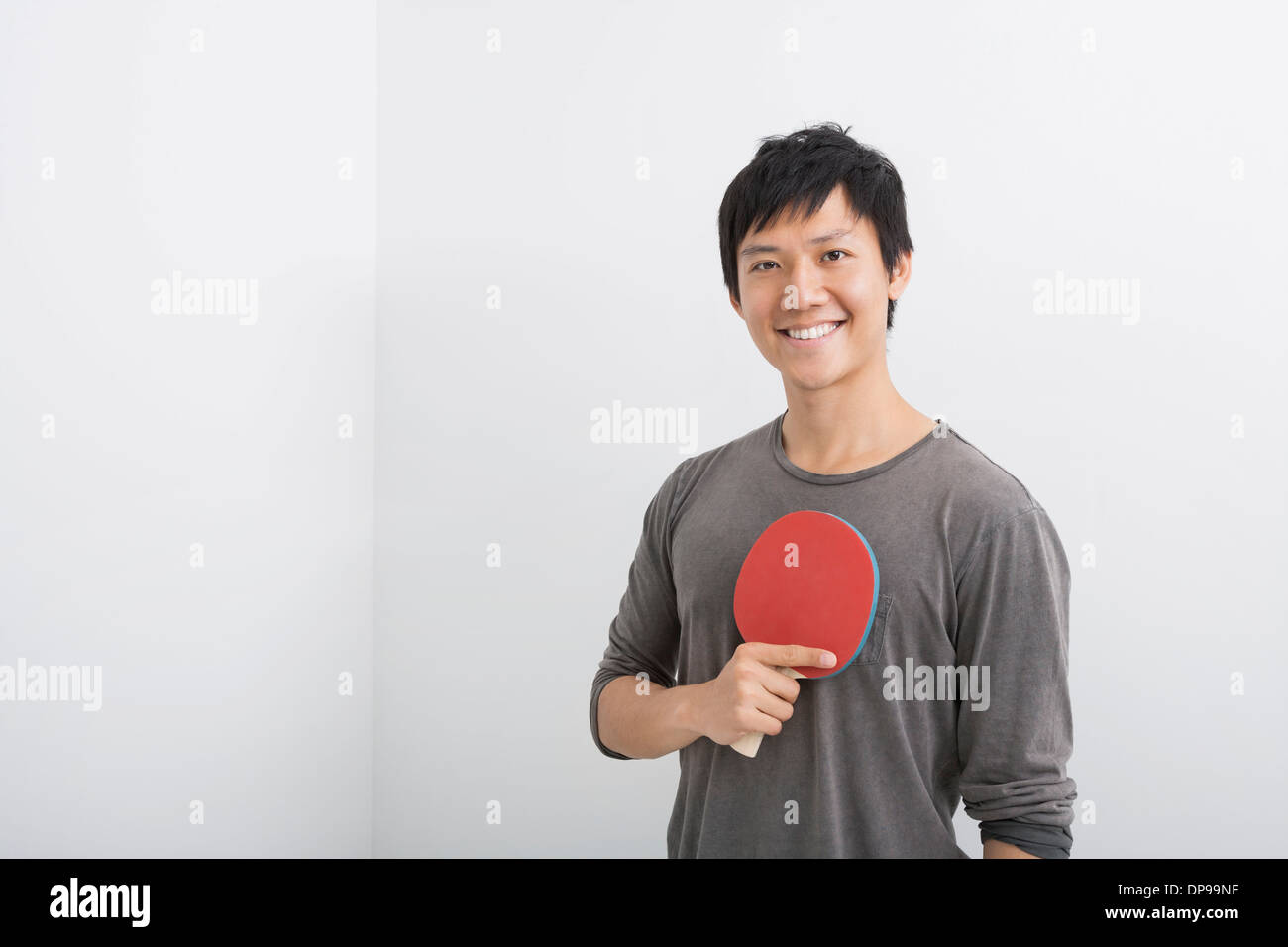Portrait of happy mid adult man holding table tennis paddle Stock Photo