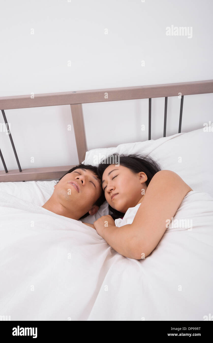 Asian couple sleeping in bed Stock Photo