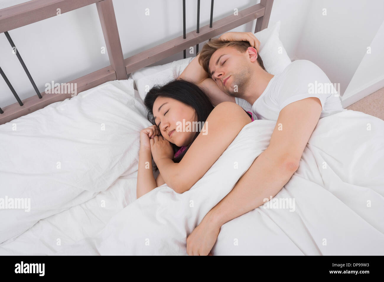 Multiethnic couple resting in bed Stock Photo