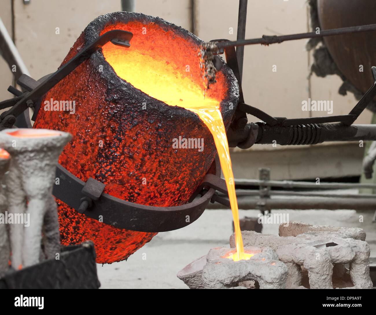 Burbank, California, USA. 9th Jan, 2014. Molten bronze is poured from a red hot cauldron on Thursday morning as metal workers at the American Fine Arts Foundry pour the statuettes that will be this year's SAG award.----Skilled craftsmen led by Master Founder Enrique Guerrero at the American Fine Arts Foundry in Burbank poured some of the last award statuettes for this years Screen Actors Guild Awards to be held January 18, 2014. Credit:  ZUMA Press, Inc./Alamy Live News Stock Photo