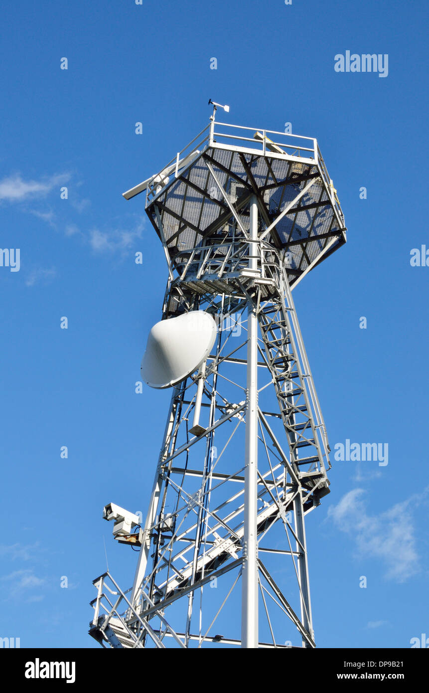Looking up at a radar tower with electronic navigation devices on clear blue sky sunny day. USA Stock Photo