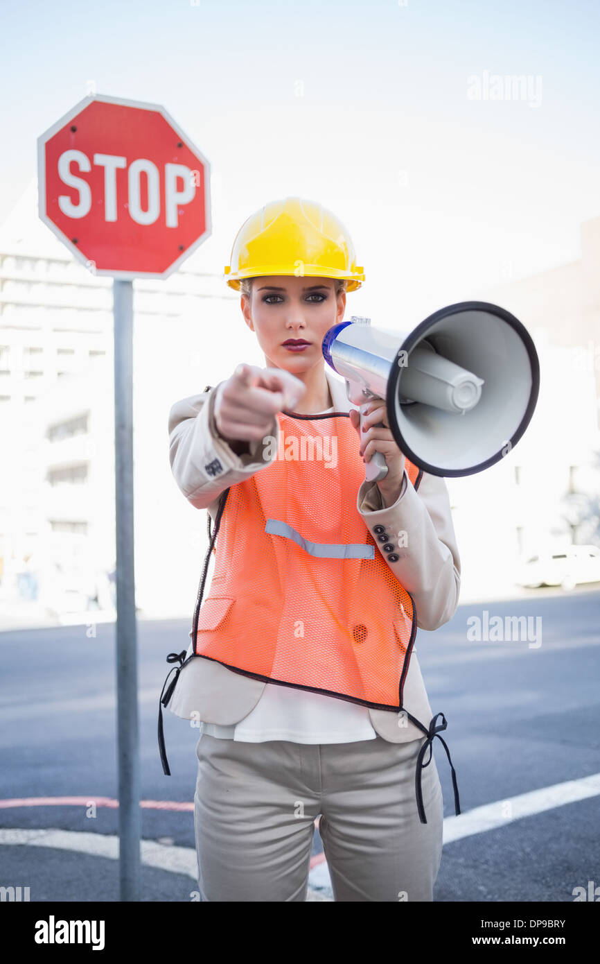 Businesswoman wearing builders clothes pointing at camera Stock Photo