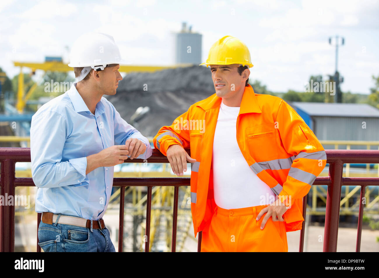 Architects standing against railing at construction site Stock Photo
