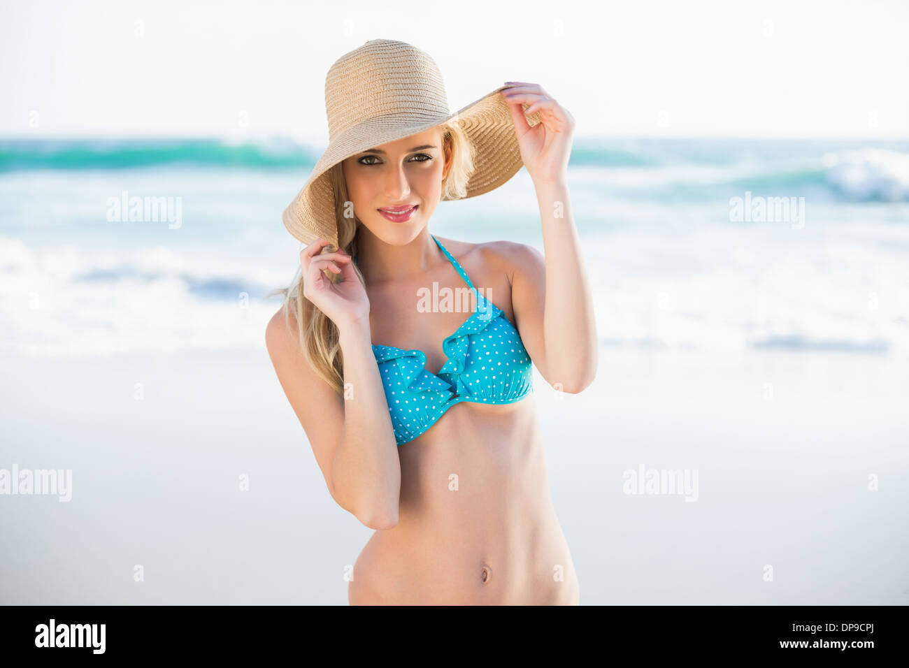 Cheerful gorgeous blonde in bikini wearing straw hat Stock Photo