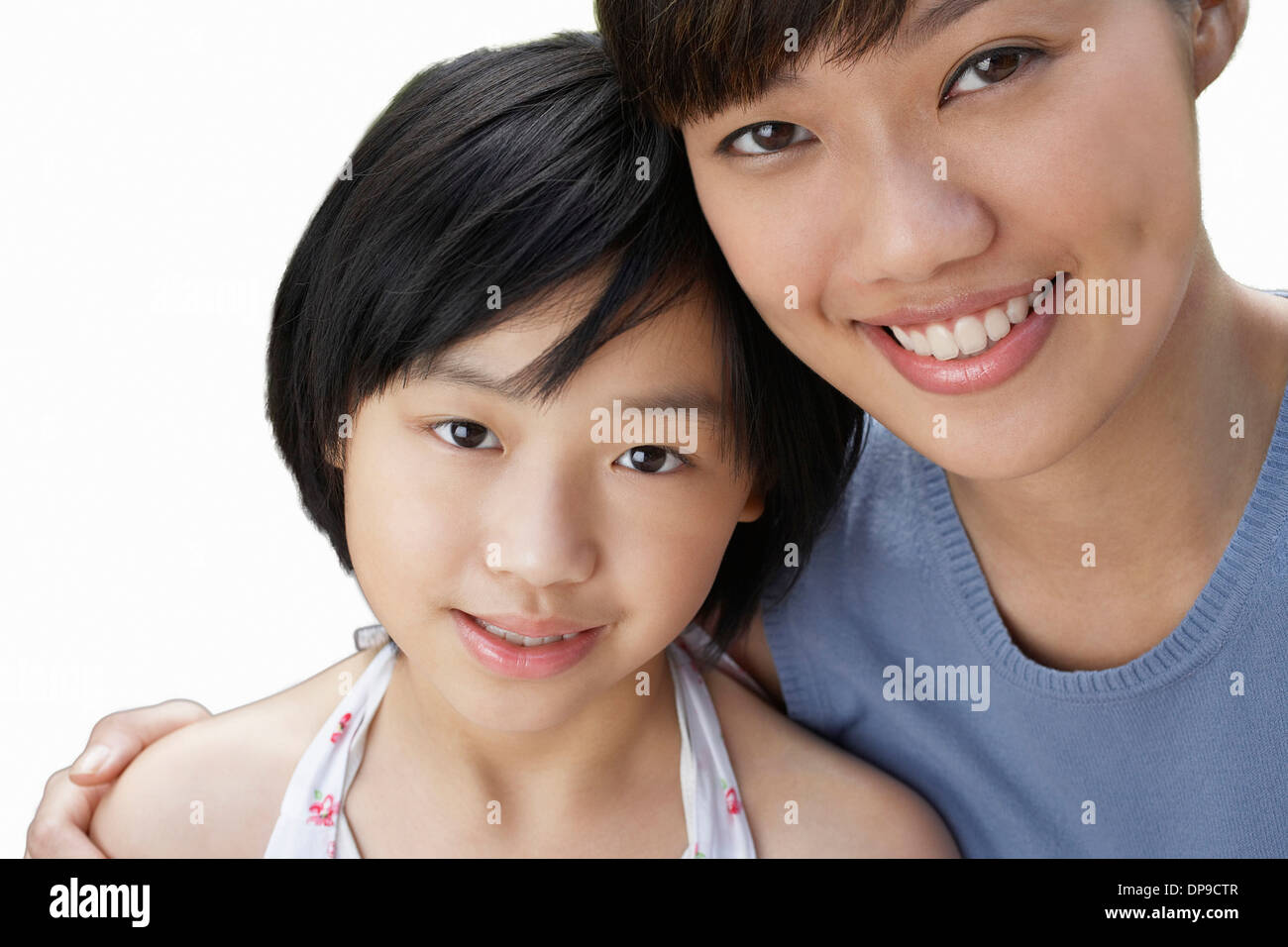 Close-up of sisters smiling over white background Stock Photo