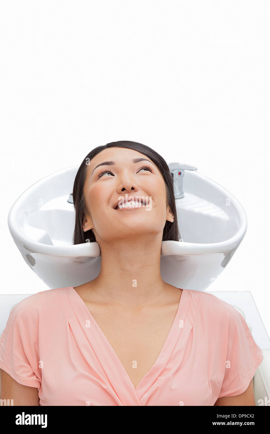 Woman resting head in sink against white background Stock Photo