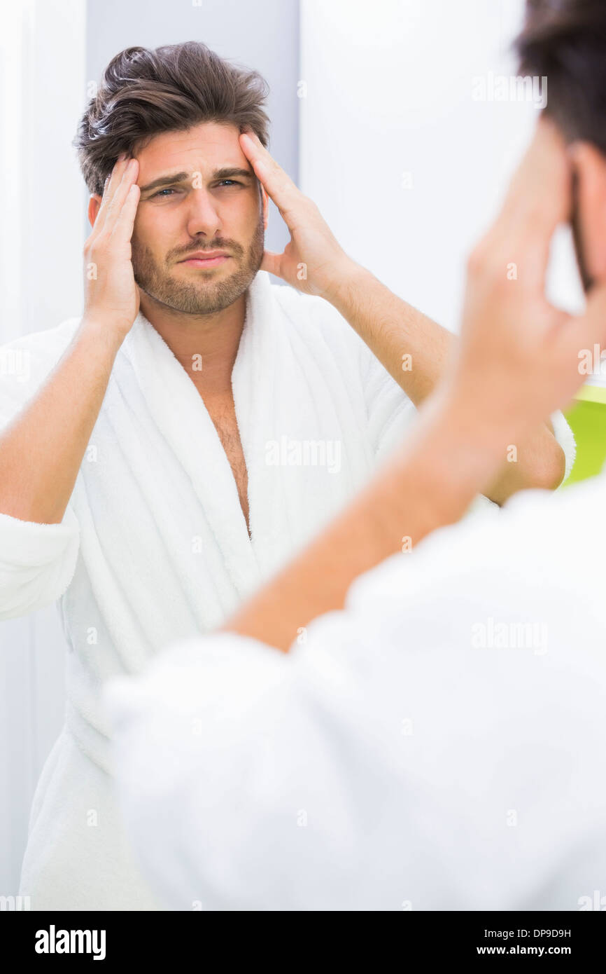 Reflection of man in bathrobe suffering from headache Stock Photo