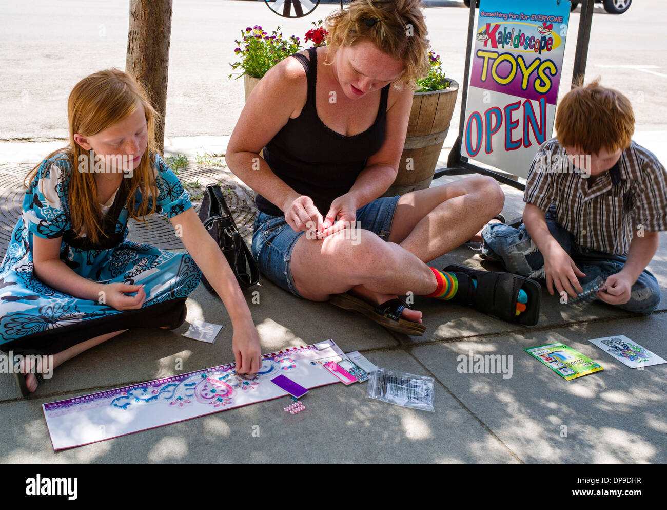 Mother and two young children doing art & crafts during the annual ArtWalk festival, Salida, Colorado, USA Stock Photo