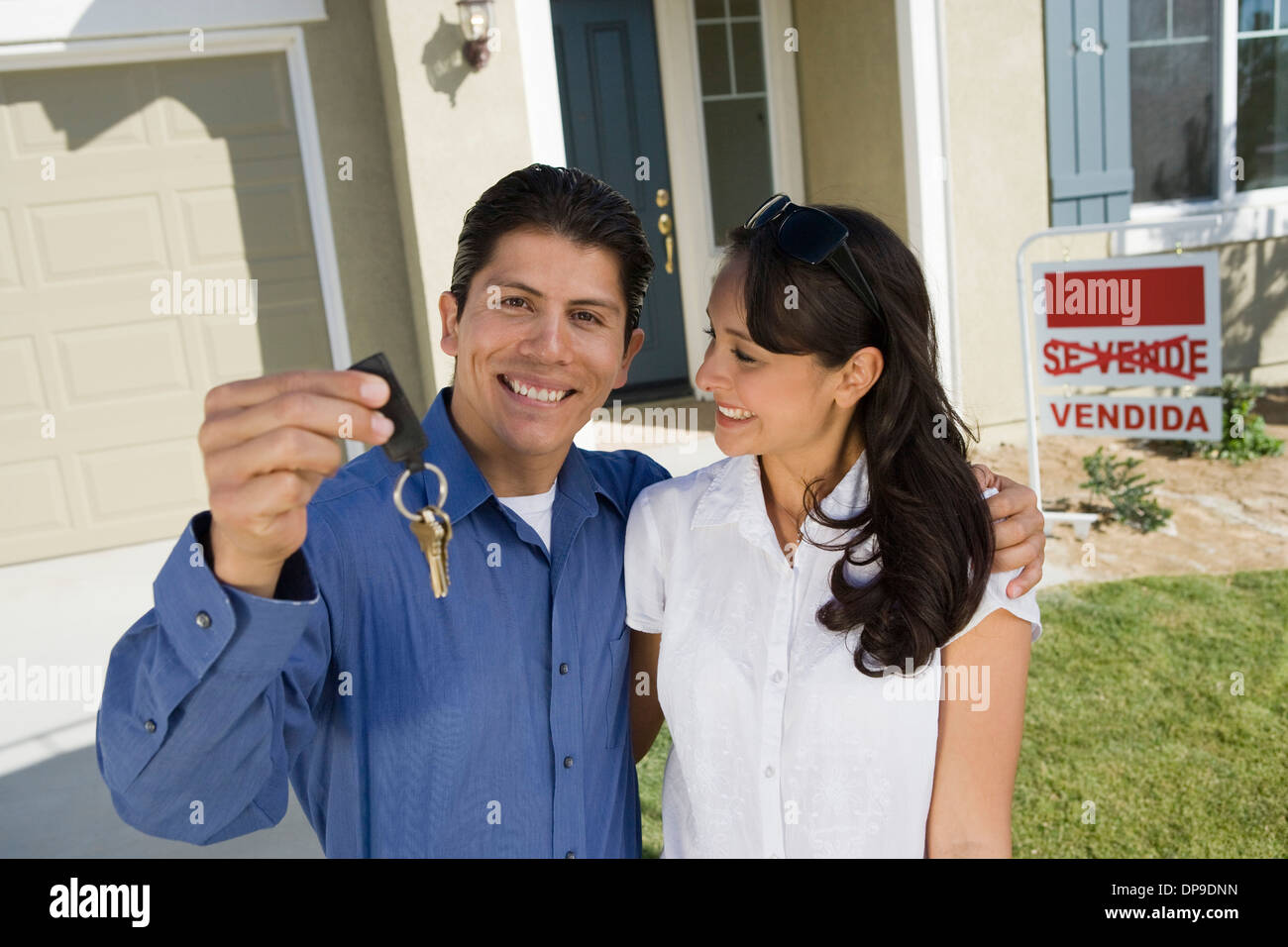 Young couple holding keys outside new home portrait Stock Photo - Alamy