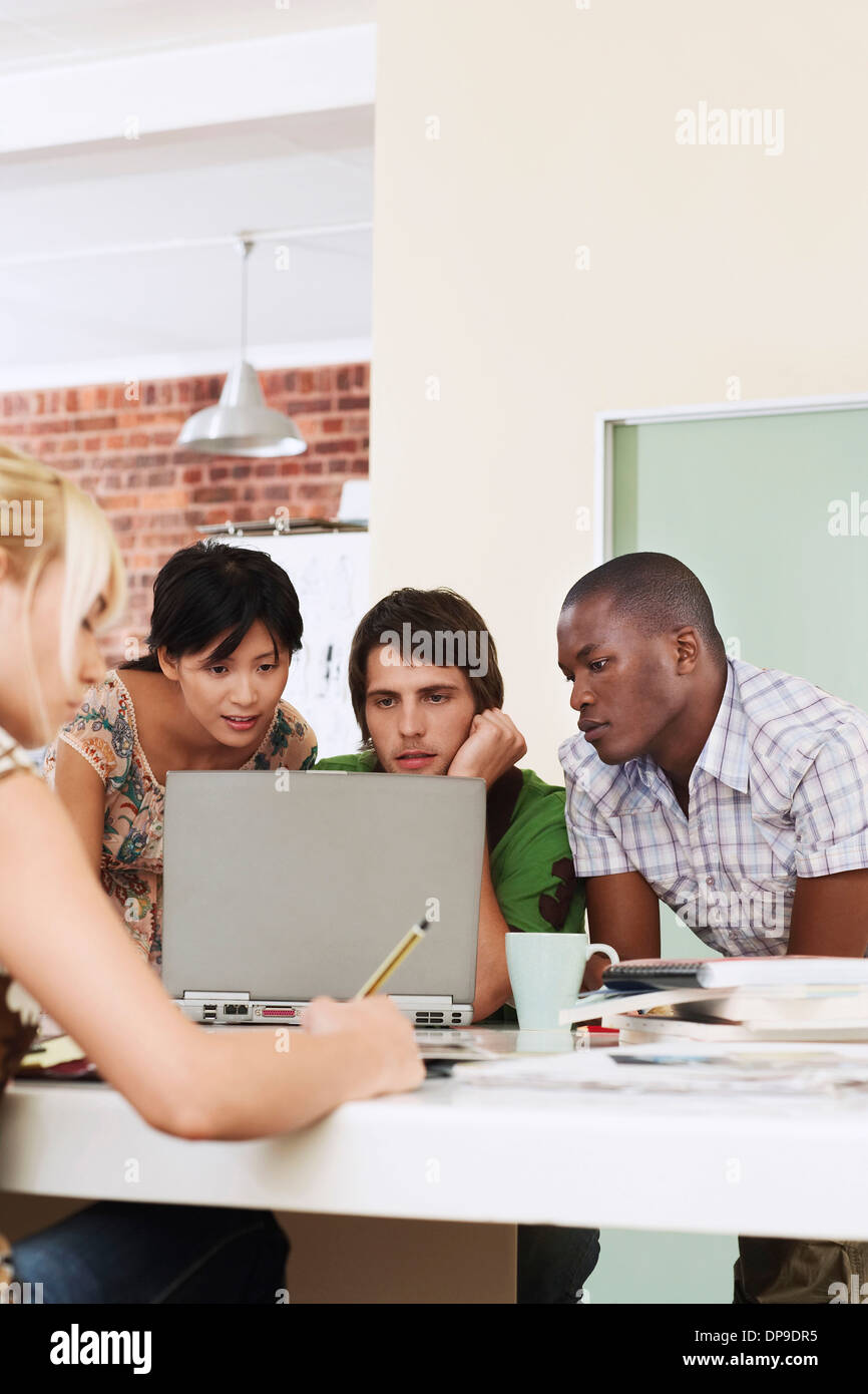 Four people having meeting around laptop. Stock Photo