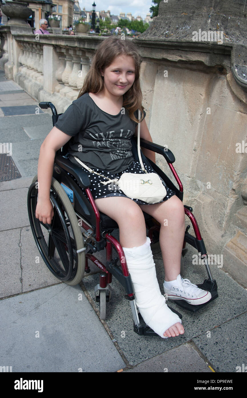 Young Girl with broken Ankle in Plaster Wheelchair FULLY MODEL RELEASED Stock Photo