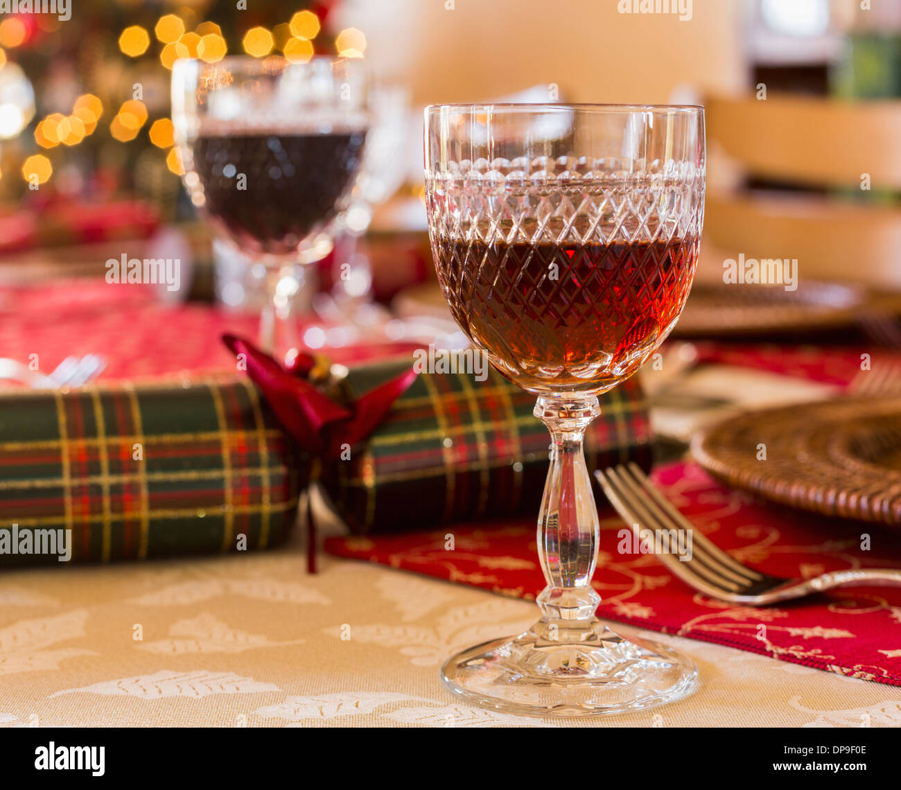 Glass of sherry on a table set for Christmas lunch with crackers and decorated tree in background Stock Photo