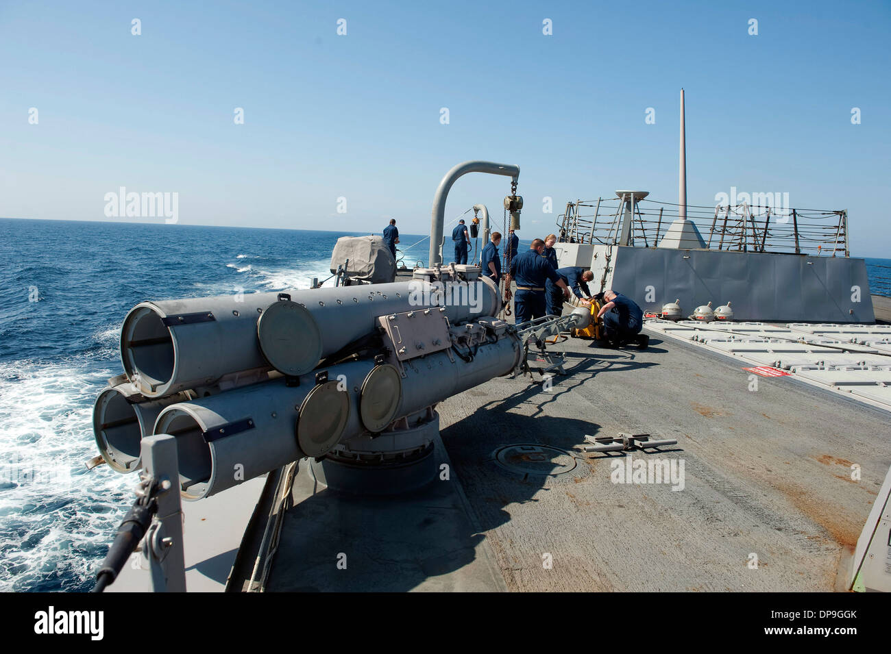 U.S. Sailors load an MK 46 torpedo aboard the guided missile destroyer USS Nitze Stock Photo