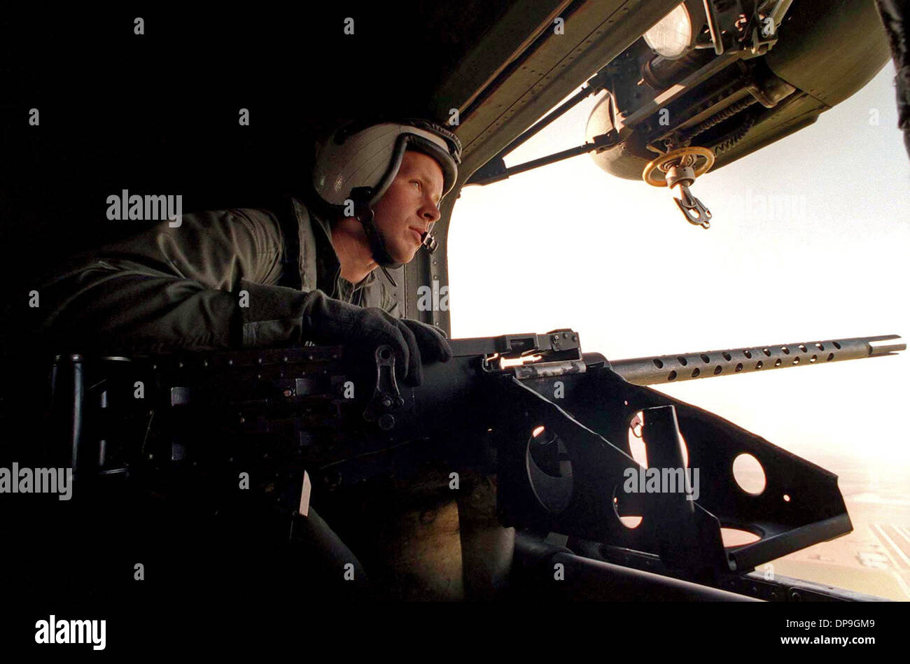 Marine Aircrewman watches out the door of a CH-53 Sea Stallion helicopter Stock Photo
