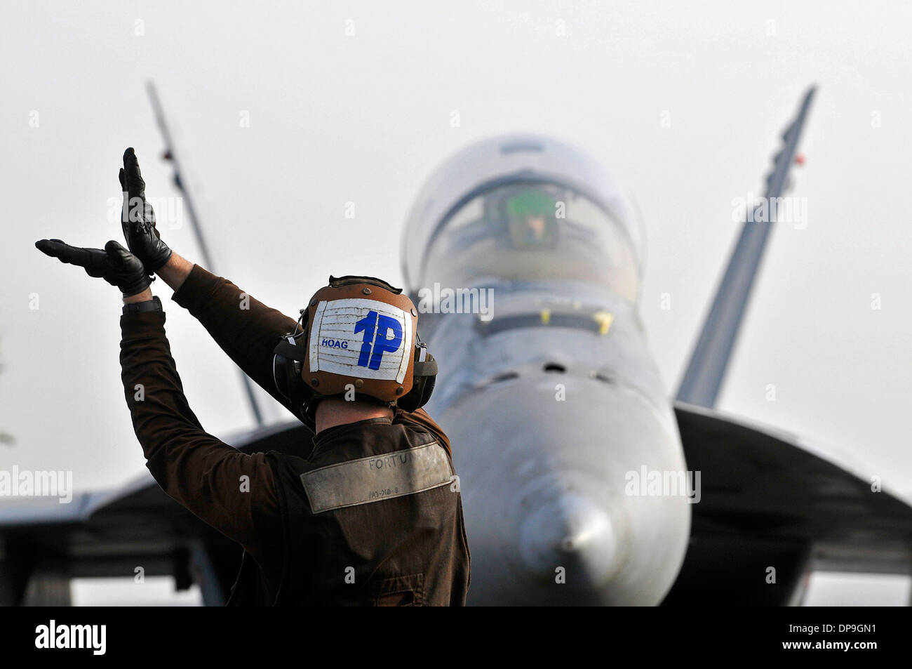 U.S. Navy Airman signals to the pilot of an F/A-18F Super Hornet aircraft Stock Photo