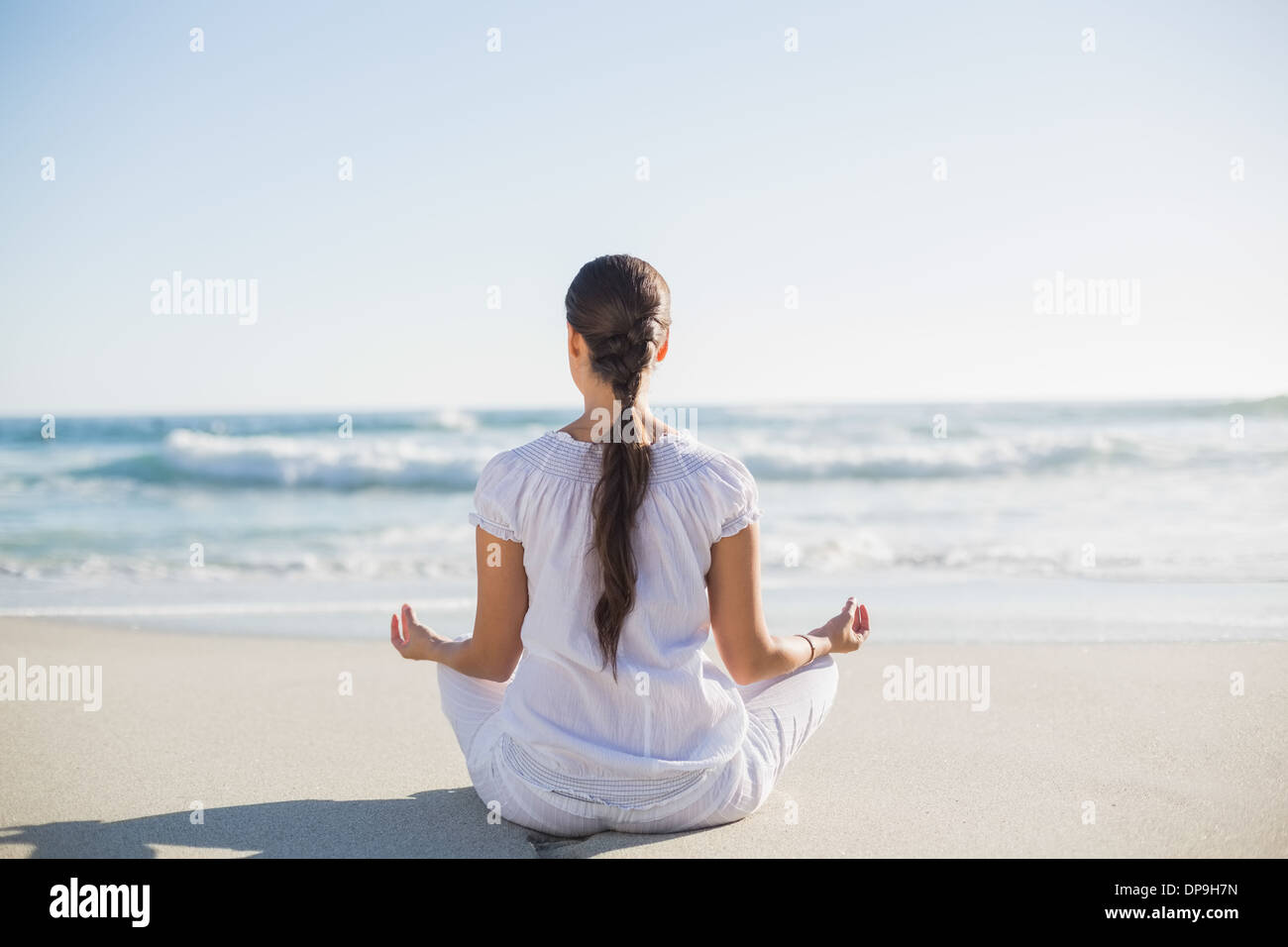 Rear view of pretty woman sitting in lotus posture Stock Photo