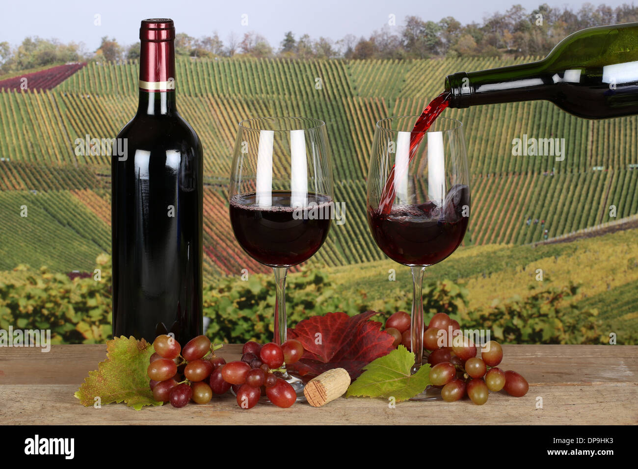 Red wine pouring from a bottle into a wine glass Stock Photo