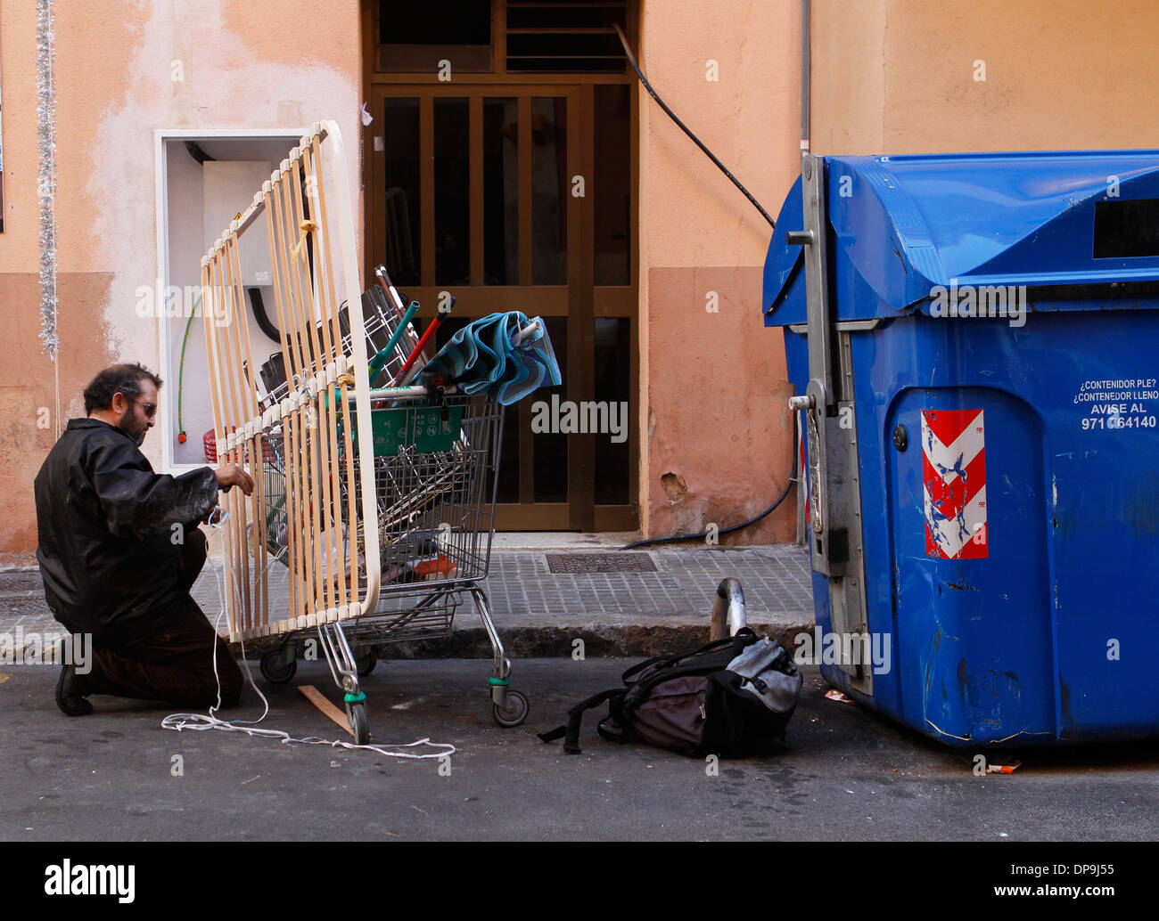 A junkman pushes his trolley where he picks between the junk copper, iron and steel to seel on local junkyards, Mallorca, Spain Stock Photo