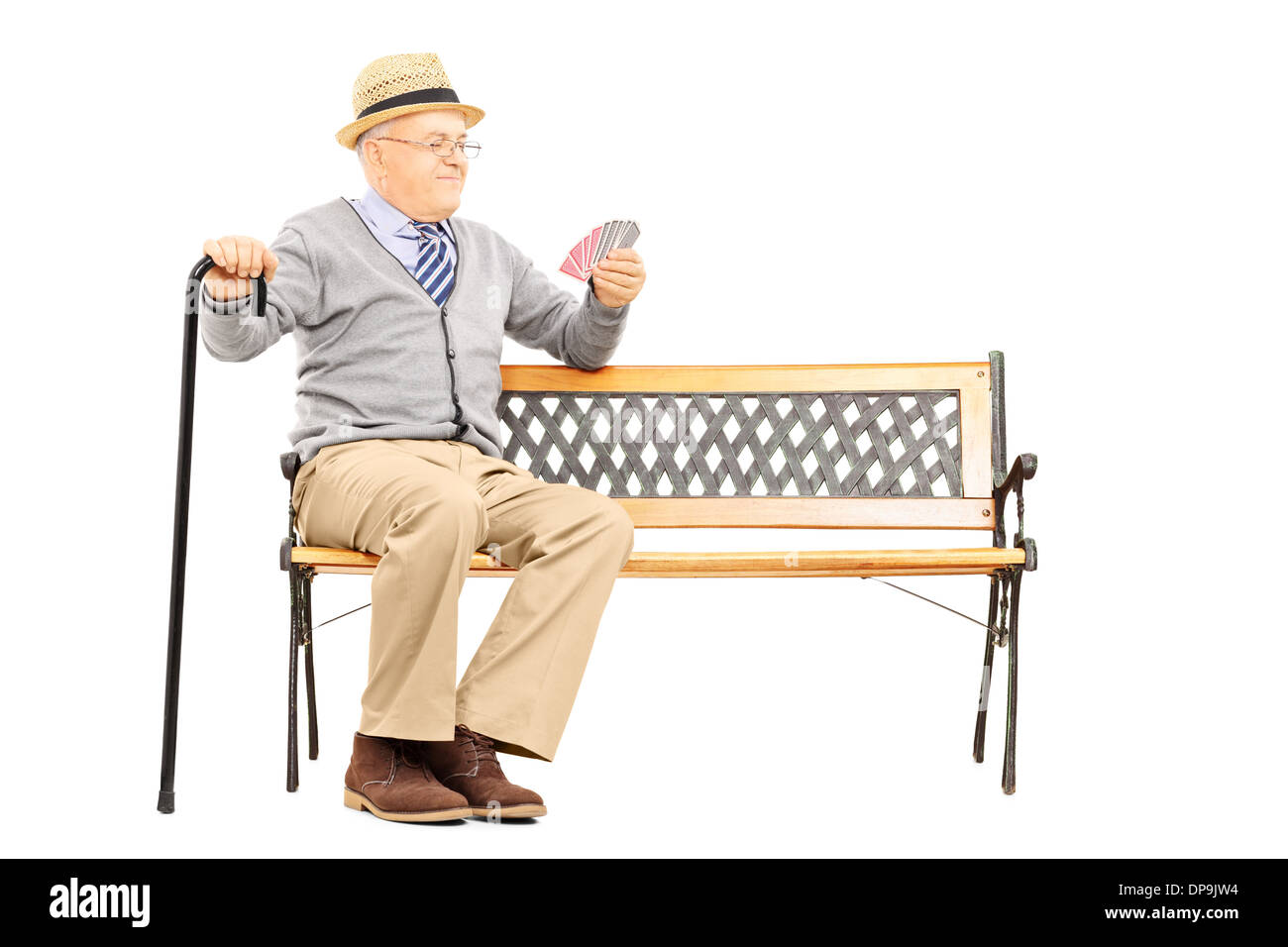 Senile old man with cane, sitting on bench imagining playing cards with someone else Stock Photo
