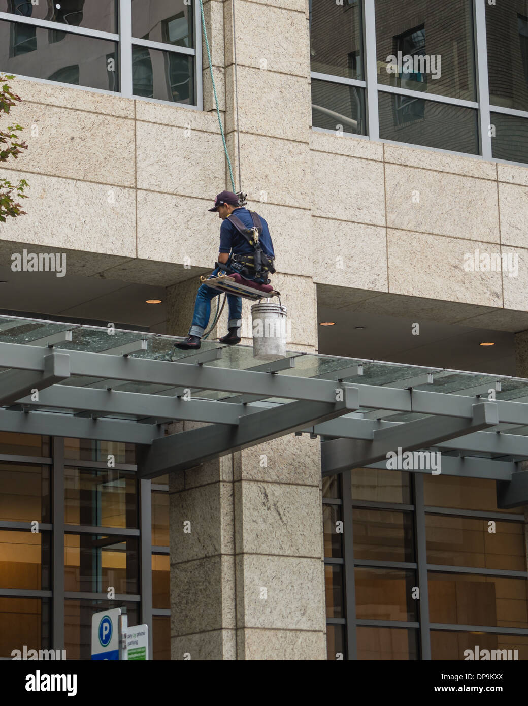Window washer cleaning windows of an office building in downtown Seattle. Seattle, Washington Stock Photo