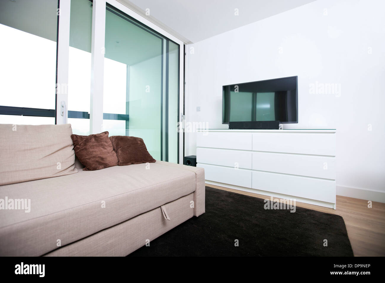 Living room with flat screen television in apartment Stock Photo