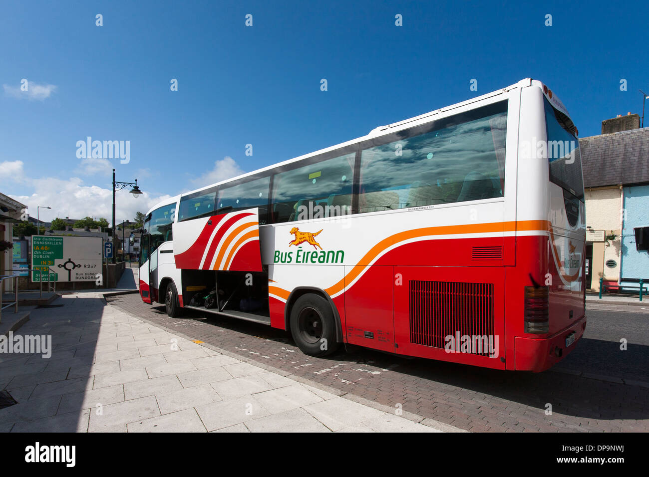 A Bus Éireann stands at the main bus station in Ballyshannon, Ireland with its luggage cpmartment open while loading passengers Stock Photo